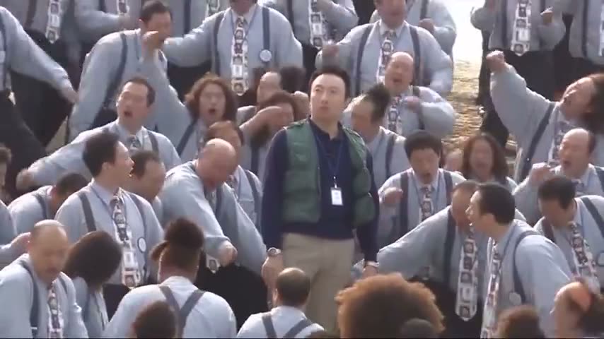 Sample 2: a man in a green vest stands still in the middle of a choir in light blue